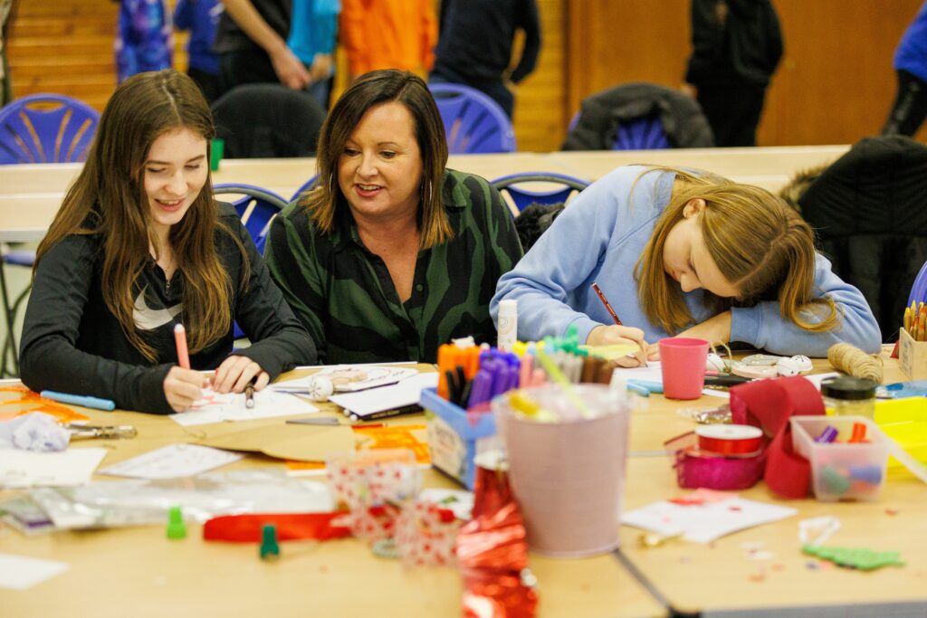 Two young people and artist at crafts table