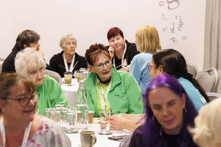 A group of adult women sitting round the table at an event